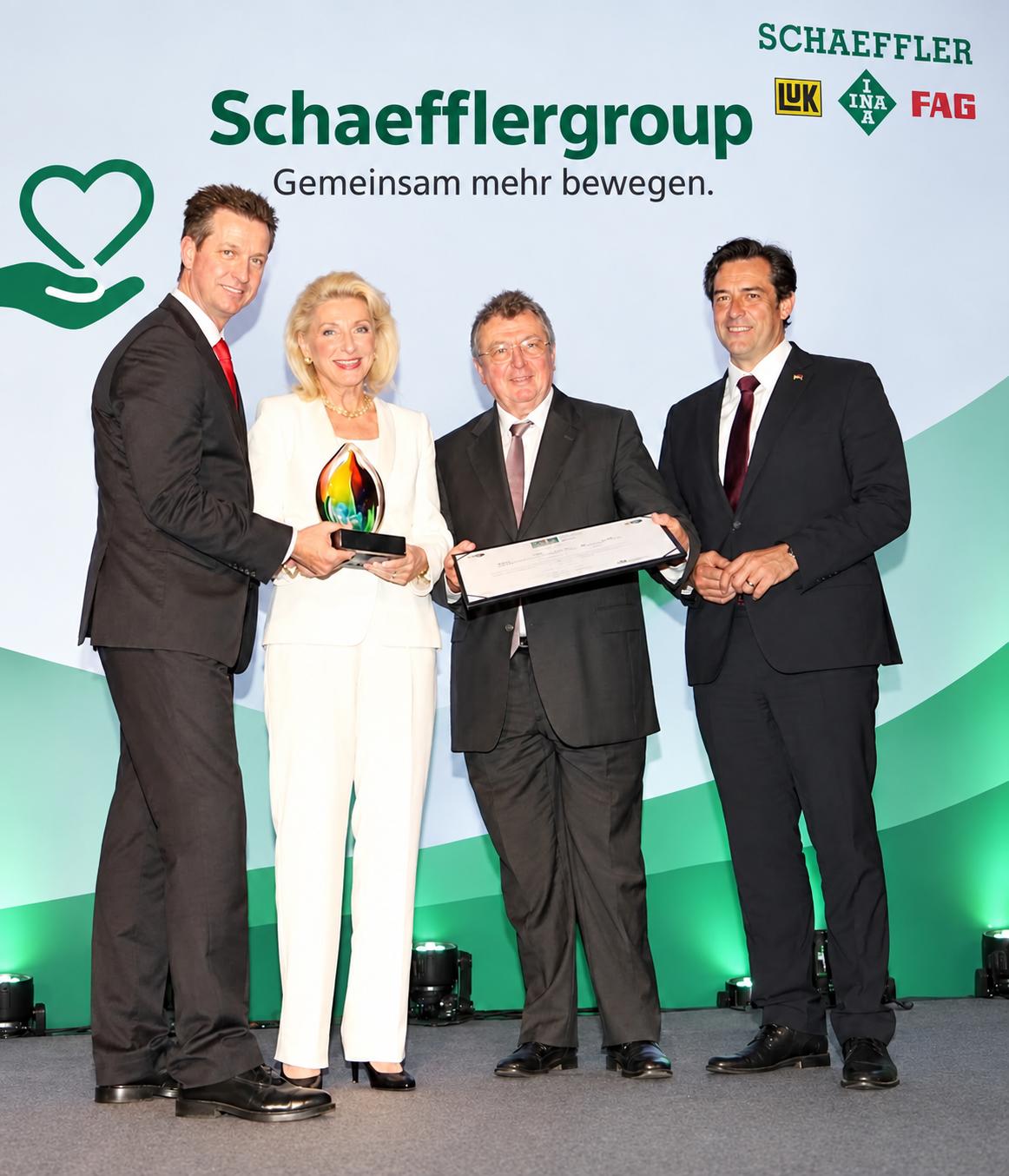 Entrepreneurs receiving an award on a gold-lit stage